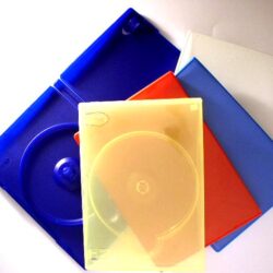 Eine Ansammlung von vier DVD-Hüllen in verschiedenen Farben: blau, rot, gelb und weiß, auf einem weißen Untergrund arrangiert.