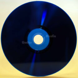 Nahaufnahme eines blauen Datenträgers auf gelbem Hintergrund, der eine reflektierende Oberfläche zeigt.