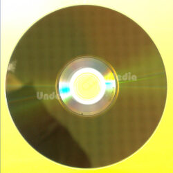 Ein goldener Blu-Ray-Rphling, der auf einem leuchtend gelben Hintergrund liegt, mit einem sichtbaren zentralen Label.