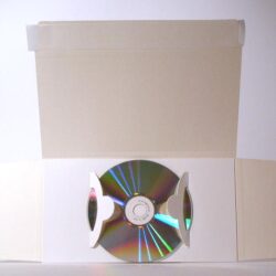 Eine weiße CD-Hülle mit einer reflektierenden Disc in der Mitte, die geöffnet ist.