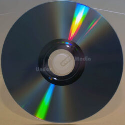 Eine nahaufnahme einer glänzenden Disc, die Regenbogenfarben reflektiert und eine klare zentrale Öffnung zeigt.