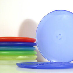 Eine stilvolle Anordnung von bunten Frisbees in Blau, Grün, Rot und mehr, auf einem weißen Hintergrund.