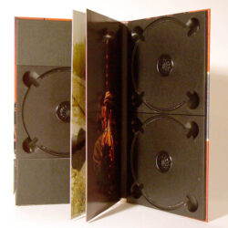 Innenansicht einer geöffneten CD-Box mit zwei schwarzen Halterungen für CDs und einem Bild auf der rechten Innenseite.