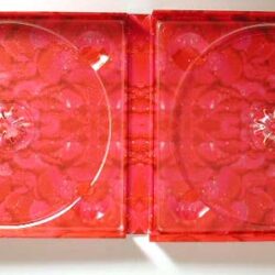 Zwei leicht transparente rote Scheiben mit einem symmetrischen Muster in der Mitte, angeordnet nebeneinander.