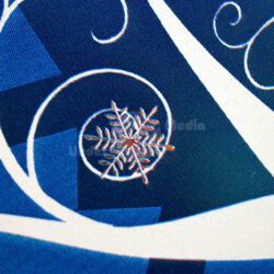 Detailansicht eines blauen Stoffes mit dekorativem Schneeflockenmotiv und verschnörkelten Linien.