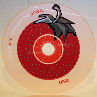 Ein transparentes CD-Design mit einem Erdbeerbild und dem Text "To help it sell, promote the smell."