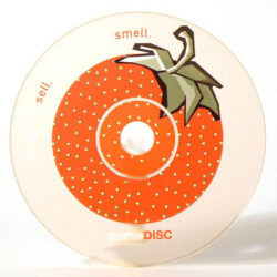 Ein DVD mit einem Erdbeer-Motiv, das grafisch gestaltete Blätter und Punkte zeigt, zusammen mit dem Text "smell." und "sell."