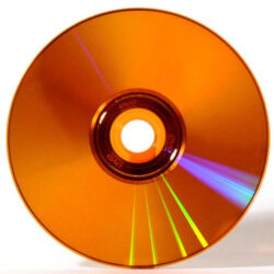 Ein roter DVD-Datenträger mit Regenbogenreflexionen.