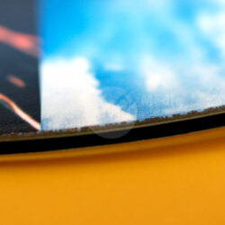 Detailaufnahme der Kante eines Skateboards mit farbigem Design und Hintergrund.