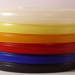 Ein Stapel farbiger Kunststoffdeckel in verschiedenen Farben, angeordnet von oben nach unten: transparent, gelb, orange, rot, blau und schwarz.