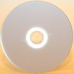 Eine leere CD, die auf einer hellen Oberfläche reflektiert, zeigt ihr schlichtes Design und die zentralen Öffnung.