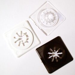 Drei farbige Abdeckungen (weiß, transparent, schwarz) für Isoliermaterialien, angeordnet auf einer weißen Oberfläche.