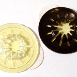 Zwei verschiedene Kaffeefilter mit transparentem und schwarzem Design, die auf einem weißen Untergrund liegen.