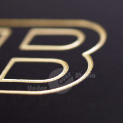 Nahaufnahme einer goldenen Buchstabenform auf schwarzem Hintergrund