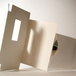 Eine offene CD-Hülle zeigt eine CD in einem transparenten Fach vor einem hellen Hintergrund.