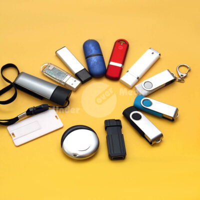 Verschiedene USB-Sticks auf gelbem Hintergrund angeordnet