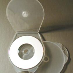 Eine transparente CD-Hülle mit einer CD in der Mitte, geöffnet und auf einem grauen Untergrund platziert.