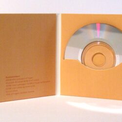 Eine geöffnete CD-Hülle mit einer silbernen Disk und aufgedruckten Systemanforderungen auf der Innenseite.