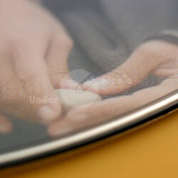 Nahaufnahme von Händen, die in sanfter Berührung liegen, mit einem reflektierenden Untergrund.