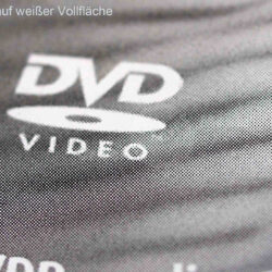 Nahaufnahme eines DVD-Logos in schwarzem Offsetdruck auf einer weißen Oberfläche