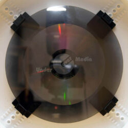 Ein CD-Glasmaster ohne Metallüberzug mit schwarzen Halterungen. Ein wichtiger Schritt in der Pressung.