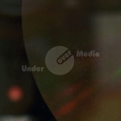 Nahaufnahme eines Glasmasters für CD-Pressung mit reflektierenden Oberflächen.