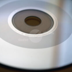 Detailaufnahme einer glänzenden CD mit einem zentralen Loch und reflektierender Oberfläche.