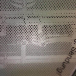 Nahaufnahme einer strukturierten Oberfläche mit geometrischen Mustern und Text in deutscher Sprache.