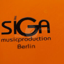 Logo von SiGA Musikproduktion auf orangefarbenem Hintergrund.