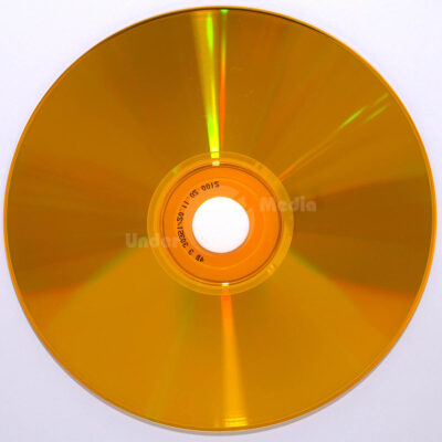 Ein goldener CD-Rohling auf einem weißen Hintergrund, der in der Mitte ein Loch aufweist.
