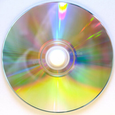 Ein glänzender CD-Rohling, der durch Lichtreflexion farbenfrohe Regenbogenmuster erzeugt.