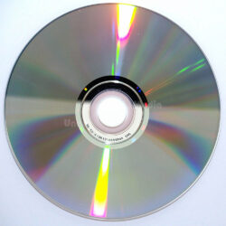 Ein glänzender CD-Disc auf weißem Hintergrund, mit sichtbaren holographischen Farben.