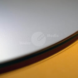 Nahaufnahme einer glänzenden Oberflächentextur auf einer runden Fläche mit weich verlaufenden Farben.