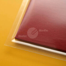 Detailaufnahme eines roten Umschlags, der auf einem leuchtend gelben Untergrund liegt.