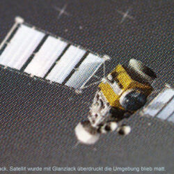 Detailaufnahme eines Satelliten mit Glanzlack-Effekt auf abgedunkeltem Hintergrund.