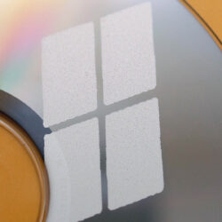 Detailaufnahme eines CD-Rohlings mit mattem Windows-Logo in der oberen Ecke.