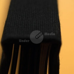 Nahaufnahme des Rücken eines schwarzen Buches auf einem gelben Hintergrund.