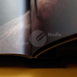 Detailaufnahme einer aufgeschlagenen Buchseite mit künstlerischem Druck und Textur.