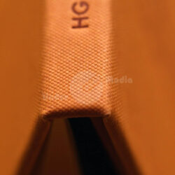 Nahaufnahme eines Buchrückens in orangefarbenem Stoff mit dem eingeprägten Text "HGHI"