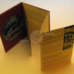 Eine geöffnete Präsentationsmappe mit einer CD und informativen Texten über die Mall of Berlin und ihre Geschichte.