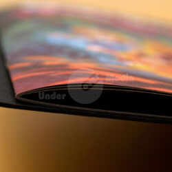 Nahaufnahme eines Buchrands mit farbigen Illustrationen und schwarzem Einband