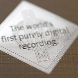 Nahaufnahme eines Abzeichens mit der Aufschrift "Die erste rein digitale Aufnahme der Welt."