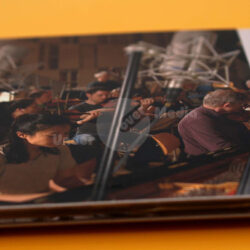 Einblick in ein Orchester während einer Aufnahmesitzung mit Mikrofonen und Musikern am Arbeitsplatz.