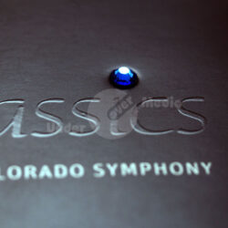Detailaufnahme eines Programms der Colorado Symphony mit einem blauen Kristall auf schwarzem Hintergrund.