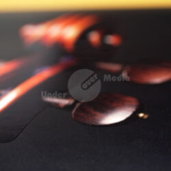 Eine Nahaufnahme von einem Teil eines Musikinstruments, das Holzdetails und einen schwarzen Hintergrund zeigt.