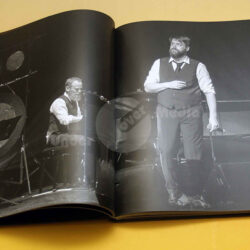 Zwei Musiker auf der Bühne, einer am Klavier und der andere im Anzug, während eines Konzerts in einem gedruckten Buch.