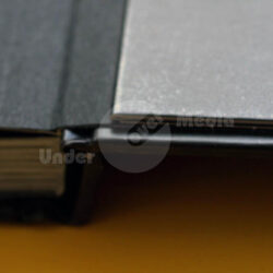 Nahaufnahme eines Buchrückens und Covers mit einem dunklen und einem reflektierenden Oberflächenbereich.