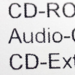 Nahaufnahme von Beschriftungen verschiedener CD-Formate: CD-ROM, Audio-CD und CD-Extra.