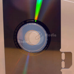 Disc in schmaler Form, mit bunten Lichtreflexionen und einem kreisförmigen Ausschnitt in der Mitte.