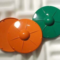 Zwei kreisrunde, bunte Scheiben in Orange und Grün auf einem neutralen Hintergrund.